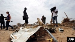 Des journalistes regardent les débris de l'avion Air Algerie vol AH 5017 au Mali, à l'ouest de Gao, 26 juillet 2014. 