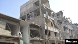 Gedung-gedung yang dirusak misil yang ditembakkan pesawat Angkatan Udara Suriahdi Douma, dekat Damaskus (17/12). (Reuters/Karm Seif/Shaam) 