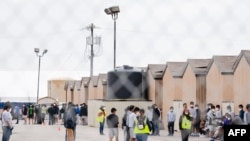 Al fondo jóvenes migrantes dentro del campo petrolífero de Cotton Logistics que se construyó en 2012 para albergar temporalmente a los trabajadores de la industria petrolera en Midland, Texas, el 5 de abril de 2021.