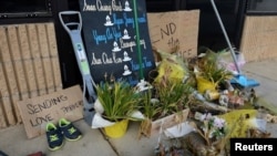 Flores secas, letreros y varias escobas, escurridores y palas bloquean la entrada del Aromatherapy Spa, en Atlanta, cuatro semanas después de los mortales tiroteos en Atlanta y Acworth, Georgia, el 13 de abril de 2021.