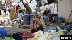 Seorang perempuan menunggu untuk mengisi air di New Delhi, India, 21 Februari 2016.