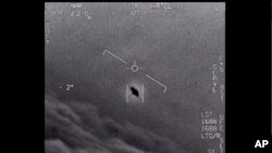 En la imagen del video proporcionado por el Departamento de Defensa etiquetado como Gimbal, de 2015, se ve un objeto inexplicable en el centro mientras se rastrea mientras se eleva a lo largo de las nubes, viajando contra el viento.