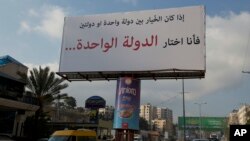 Un mensaje en una pancarta apoya la creación de un Estado único para israelíes y palestinos que dice en árabe: "Si tuviera que elegir entre un Estado y dos Estados, elegiría un Estado", en la ciudad cisjordana de Ramala, el 23 febrero de 2017.