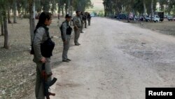 FILE - Kurdish Democratic Union Party (PYD) members stand guard during a Labour Day celebration in Efrin, Syria, May 1, 2014.