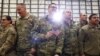 Un miembro de la Fuerza Aérea de EE.UU. sostiene una bandera estadounidense mientras el presidente Donald Trump habla a personal militar en la base aérea Bagram en Afganistán, el 28 de noviembre de 2019.
