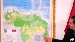 ARCHIVO - El presidente de la Comisión Especial para la Defensa del Esequibo, Hermann Escarra, habla junto a un nuevo mapa de Venezuela que incluye la región del Esequibo, el 8 de diciembre de 2023, en Caracas, Venezuela. 