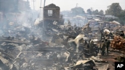 Remains of vendor stalls still smoulder after a fire swept through a market in Nairobi, Kenya, June 28, 2018.