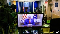 Slika na monitoru pokazuje predsednika SAD Donalda Trampa koji govori u videu postavljenom na Tviter nalogu Bele kuće, u praznoj sali za brifinge Bredy, u Beloj kući u Vašingtonu, 13. januara 2021.