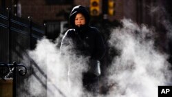 Una mujer protegida contra el frío camina en una manaña de otoño por Filadelfia, el miércoles 13 de noviembre de 2019. Una ola de frío polar avanza del centro-oeste del país hacia la costa este, rompiendo récords de sur a norte. AP/Matt Rourke.