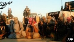 FILE - This scene from a propaganda video released June 8, 2014, allegedly shows militant group Islamic State fighters gathered near Tikrit, Iraq.
