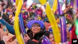 Una mujer sonríe en la celebración de Nochevieja en Times Square en Nueva York, el domingo 31 de diciembre de 2023.