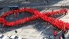 FILE - High school students make a formation in the shape of the red ribbon, the universal symbol of awareness and support for those living with HIV, during a campaign to mark World AIDS Day in Seoul, South Korea, Dec. 1, 2103. 