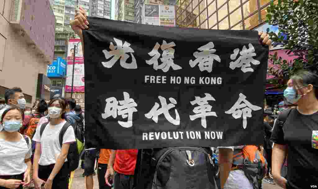 參與5-24港島反惡法遊行的人士高舉反送中運動的”光復香港、時代革命”標語,高舉這面標語旗幟在港版中國國家安全法實施後,可能會觸犯相關法例。(美國之音湯惠芸拍攝)