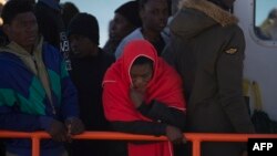 Para migran antre menaiki kapal garda pantai Spanyol saat tiba di pelabuhan Malaga, 10 Desember 2018, setelah perahu karet bermuatan 118 migran diselamatkan garda pantai Spanyol di lepas pantai Spanyol.
