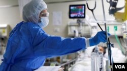 Un trabajador sanitario atiende a un paciente en cuidados intensivos en el Hospital El Salvador, en Lima, el 22 de diciembre de 2020.