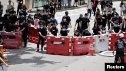 Para pengunjuk rasa membentuk barikade saat mereka memblokir satu dari jalan utama di Hong Kong, China, 21 Juni 2019 (foto: Reuters/Ann Wang)