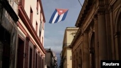 Bendera Kuba berkibar di sebuah jalan di tengah kekhawatiran tentang penyebaran virus corona di pusat kota Havana, Kuba, Minggu, 18 Juli 2021. (Foto: Alexandre Meneghini/Reuters)