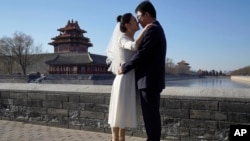 แฟ้ม - บ่าวสาวโพสต์ถ่ายภาพที่กรุงปักกิ่ง 20 ธ.ค. 2020 (AP Photo/Ng Han Guan)