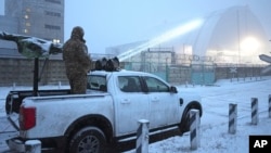 A Ukrainian serviceman stands on a vehicle with anti-aircraft gun after a drone attack at the former Chernobyl nuclear power plant, Ukraine, Feb. 14, 2025.