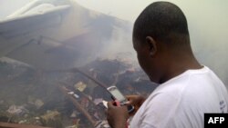A man using his cell phone in a neighborhood just north of Murtala Muhammed International Airport, in Lagos, Nigeria, June 3, 2012.