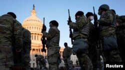 Miembros de la Guardia Nacional reciben armas antes de que los demócratas comiencen a debatir un artículo de juicio político contra el presidente de Estados Unidos, Donald Trump, en el Capitolio de Estados Unidos, en Washington, el 13 de enero de 2021. 