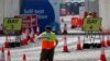 Seorang petugas menunggu peserta tes Covid-19 di fasilitas lantatur (drive thru) stadion Twickenham, London, yang sepi pengunjung, 17 September 2020. (AP Photo/Frank Augstein) 