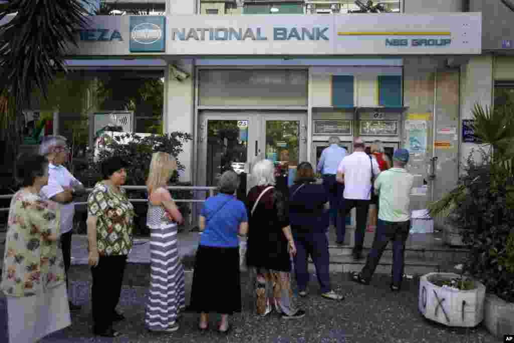 Warga Yunani antre di sebuah ATM di luar sebuah bank yang tutup di Athena, Selasa (30/6). (AP/Thanassis Stavrakis)