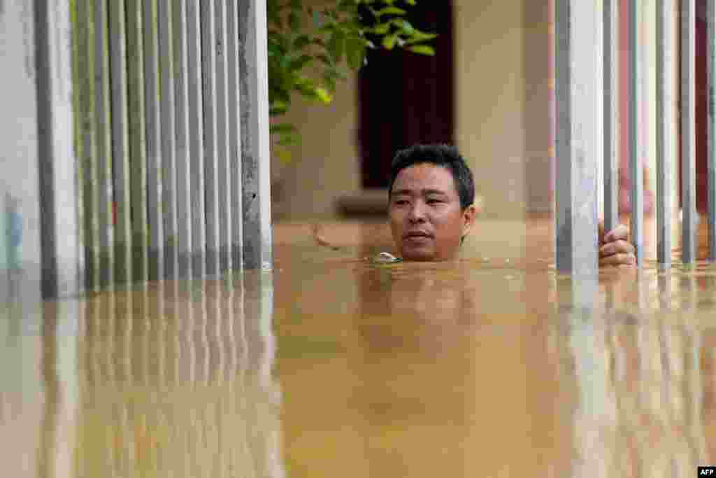 A man wades through flood waters outside his house in Thai Nguyen province in the aftermath of Typhoon Yagi hitting northern Vietnam. Tens of thousands of people were forced to flee their homes as massive floods inundated northern Vietnam and the death toll climbed to 82. 