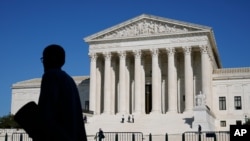 Officials stand on the Supreme Court steps on Capitol Hill in Washington, Tuesday, Sept. 22, 2020, as preparations take place for a private ceremony and public viewing in remembrance of Justice Ruth Bader Ginsburg. (AP Photo/Patrick Semansky)