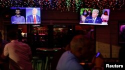 TV ekrani sa predsedničkim kandidatom demokrata Džoom Bajdenom (levo) i predsednikom SAD Donaldom Trampom, koji učestvuju na predsedničkim izborima 2020, u restoranu u Tampi na Floridi, 15. oktobra 2020. (Foto: Reuters/Octavio Jones)