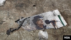 Una foto pisoteada y semidestruida de Gadhafi, se podía ver en el suelo en el complejo Bab al-Aziziya, en Trípoli.