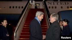 Menteri Luar Negeri AS John Kerry, kiri, disambut oleh Duta Besar AS untuk China Max Baucus setibanya di Beijing, 26 Januari 2016.