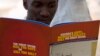 FILE - A man reads a publication by a civil society coalition on human rights and constitutional law in Kampala.