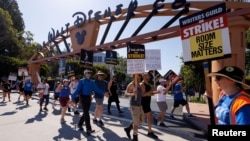 Glumci, članovi udruženja SAG-Aftra i scenaristi iz Udruženja američkih scenarista protestuju ispred studija Dizni u Burbenku u Kaliforniji, 25. jula 2023. (Foto: Rojters/Mike Blake)