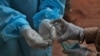 Un trabajador de salud se limpia las manos con desinfectante luego de tomar una muestra a un paciente en un centro de pruebas de covid en Hyderabad, India, el domingo 11 de octubre de 2020. 