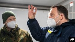 Jens Spahn, German Minister of Health, with Julian Brederlow, senior staff pharmacist, at Bundeswehr pharmacy in Quakenbrueck, Germany, May 14, 2021. He said the national average infection rate fell to 96.5 per 100,000, its lowest level since March 20.