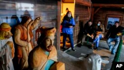 Seorang petugas medis dan beberapa warga tampak menunggu di pasar natal di Offenbach, Jerman, pada 24 November 2021, untuk mendapatkan vaksin COVID-19. (Foto: AP/Michael Probst)