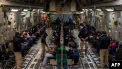 Ova slika koju je objavilo Ministarstvo odbrane prikazuje migrante bez dokumenata koji čekaju polijetanje na let na međunarodnom aerodromu Tucson, Arizona, 23. januara 2025. (AFP fotografija/DVIDS/Ministarstvo odbrane/Viši zrakoplovac Devlin Bishop)