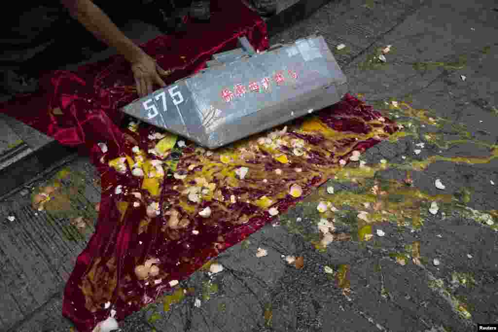 Anti-Vietnam protesters throw eggs at a Chinese frigate placed on top of a Vietnamese flag during a protest defending China's territorial claim and condemning Vietnam's anti-Chinese protests, in Hong Kong, May 19, 2014. 