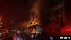 Ljudi stoje nedaleko od zgrade u požaru, u Johanesburgu, Južna Afrika, 31. avgusta 2023.