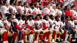 Members of the San Francisco 49ers kneel during the national anthem as others stand during the first half of an NFL football game against the Arizona Cardinals, Oct. 1, 2017, in Glendale, Arizona.