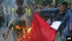 西藏流亡人士1月17日在印度新德里抗議期間﹐焚燒中國國旗和象徵中國官員的假人。