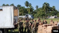 Tropas estadounidenses descargan alimentos para un orfanato destruido por el terremoto.