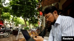 FILE - Vietnamese activist Anh Chi searches the internet at Tu Do (Freedom) cafe in Hanoi, Aug. 25, 2017. Amnesty International has found that a hacking group known as Ocean Lotus has been staging more spyware attacks on Vietnamese human rights activists.