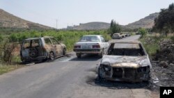 Vista de vehículos calcinados a ambos lados de una carretera en la localidad cisjordana de al-Mughayyir, el 13 de abril de 2024.