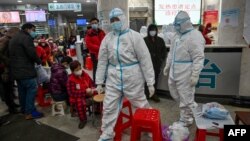 武漢紅十字醫院身穿防護服的醫務人員和等候就診的病患。（2020年1月25日）