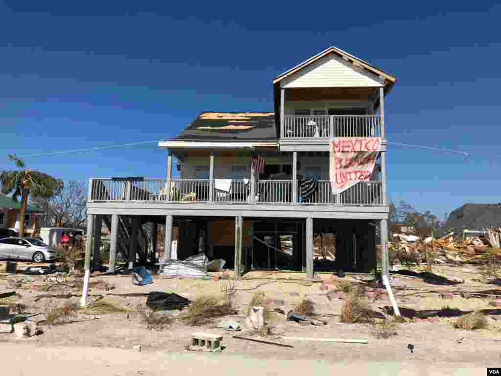 Un cartel que dice "Mexico Beach Unidos", cuelga de lo que queda de una casa en Mexico Beach, Florida, la comunidad costera junto a Panama City, Florida, que recibió el impacto más fuerte del huracán Michael el 10 de octubre de 2018. Sábado 13 de octubre de 2018. Foto, Jorge Agobián.