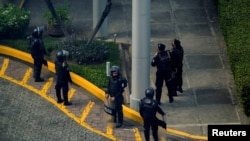 Fuerzas militares del gobierno de Nicaragua apostados a las afueras de la sede del diario independiente Confidencial mientras allanan la instalación el 20 de mayo de 2021.