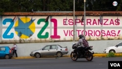 Un motociclista pasa frente a un cartel en una pared en Managua, capital de Nicaragua, en noviembre de 2021, tras las discutidas elecciones que dieron la victoria al Nadiel Ortega. [Foto: VOA/Houston Castillo]