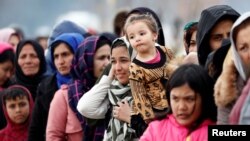Des migrants attendent de recevoir de l'aide alimentaire au poste frontière turc de Pazarkule, voisin de Kastanies en Grèce, le 5 mars 2020.